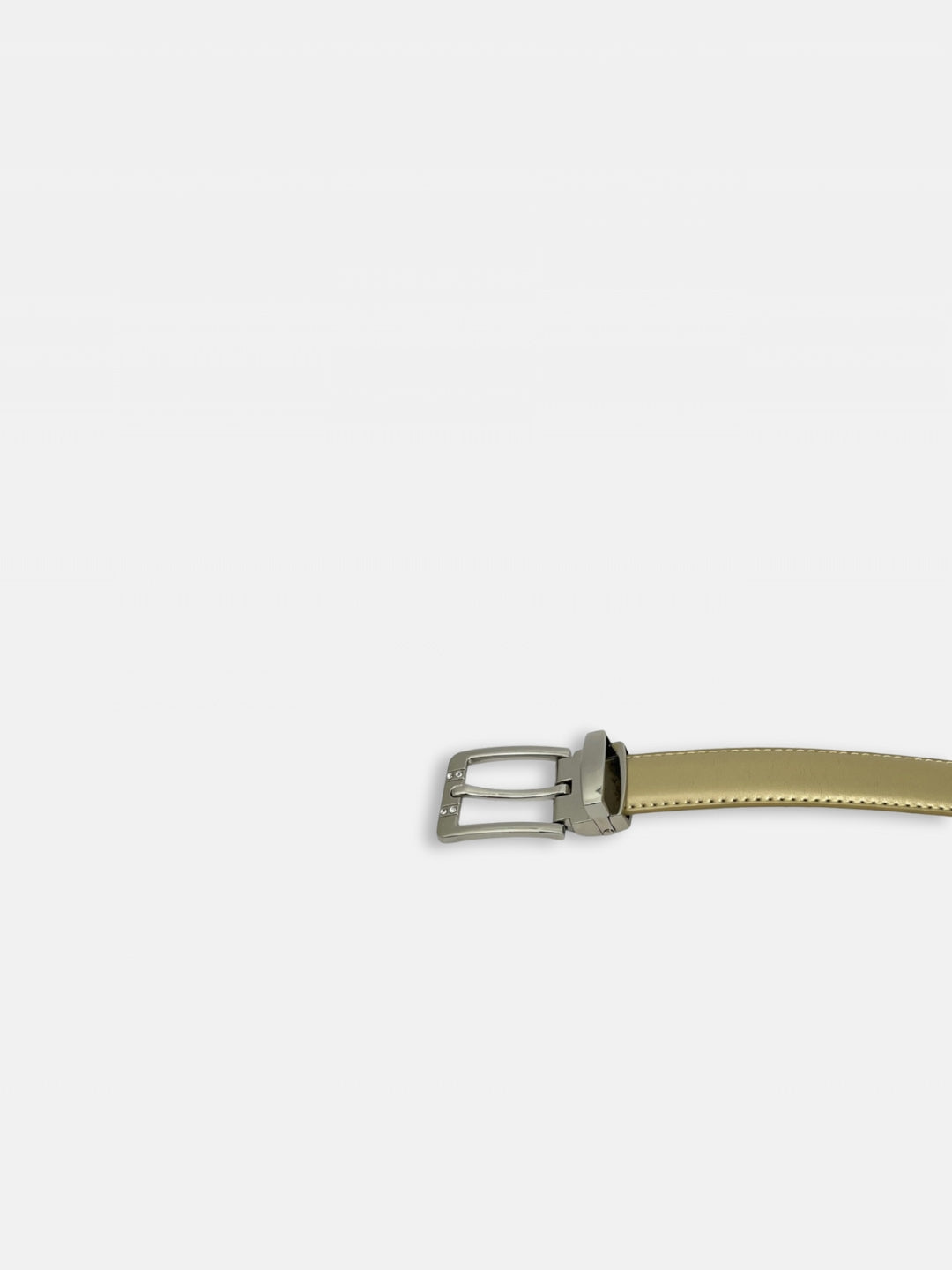 Ceinture fine en cuir beige doré avec boucle à ardillon chromée dissimulant deux petits strass de chaque coté de l'ardillon. Sur fond gros clair. Vue boucle